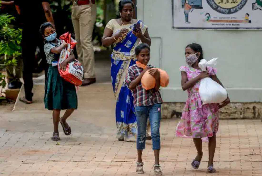 Indian children collect rice and lentils from a school in the southern city of Chennai on July 24 as part of a government free meal program for schoolchildren during the Covid-19 pandemic