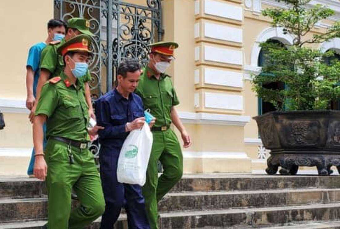 Tran Van Bang (in dark blue shirt) is coming out of a court in Ho Chi Minh City on May 12