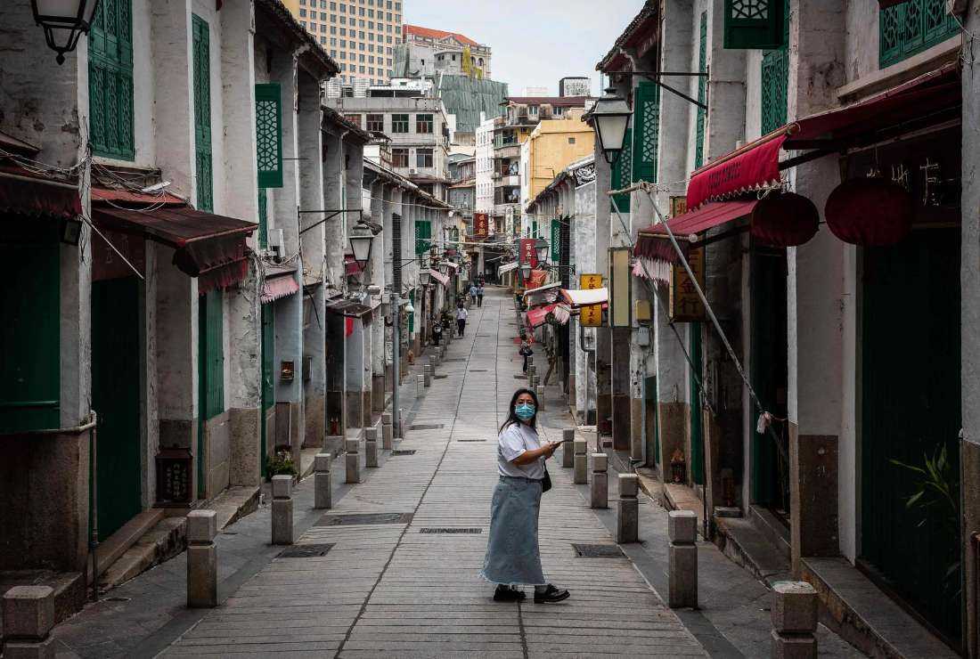 A pedestrian looks on as she walks in a street in the historical center in Macau on Oct. 10