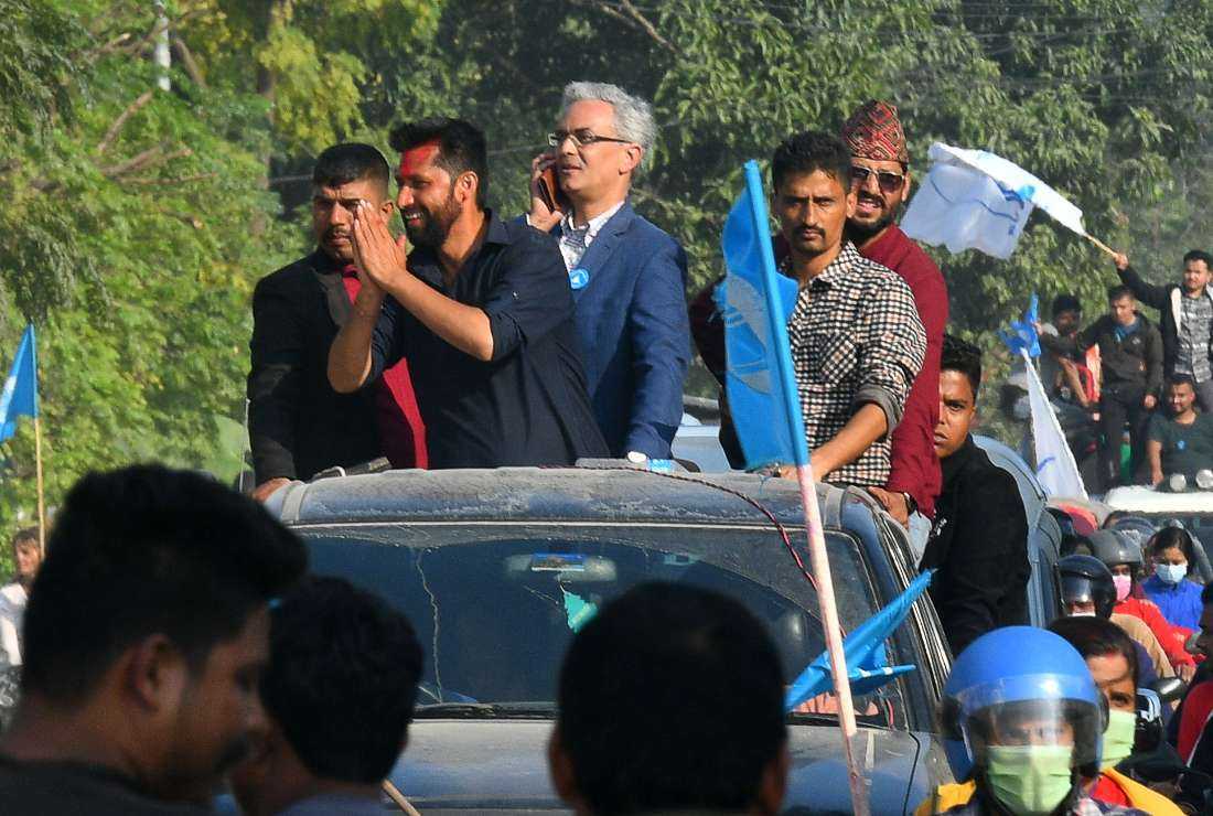 Former television host and Independent Party's candidate in Nepal's general election Rabi Lamichhane (center) gestures from atop a vehicle as he arrives for a door-to-door election campaign event in Padampur on Nov. 12