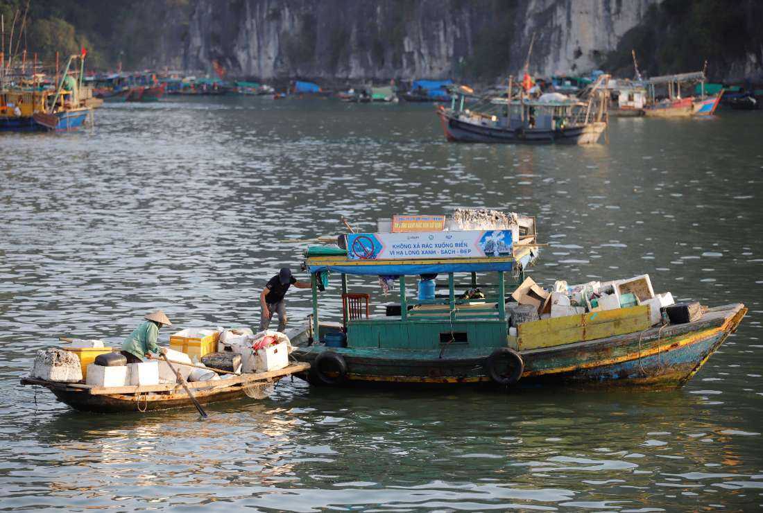 This photo taken on May 17 shows workers on a boat after picking up foam buoys floating in Ha Long Bay in northeast Vietnam